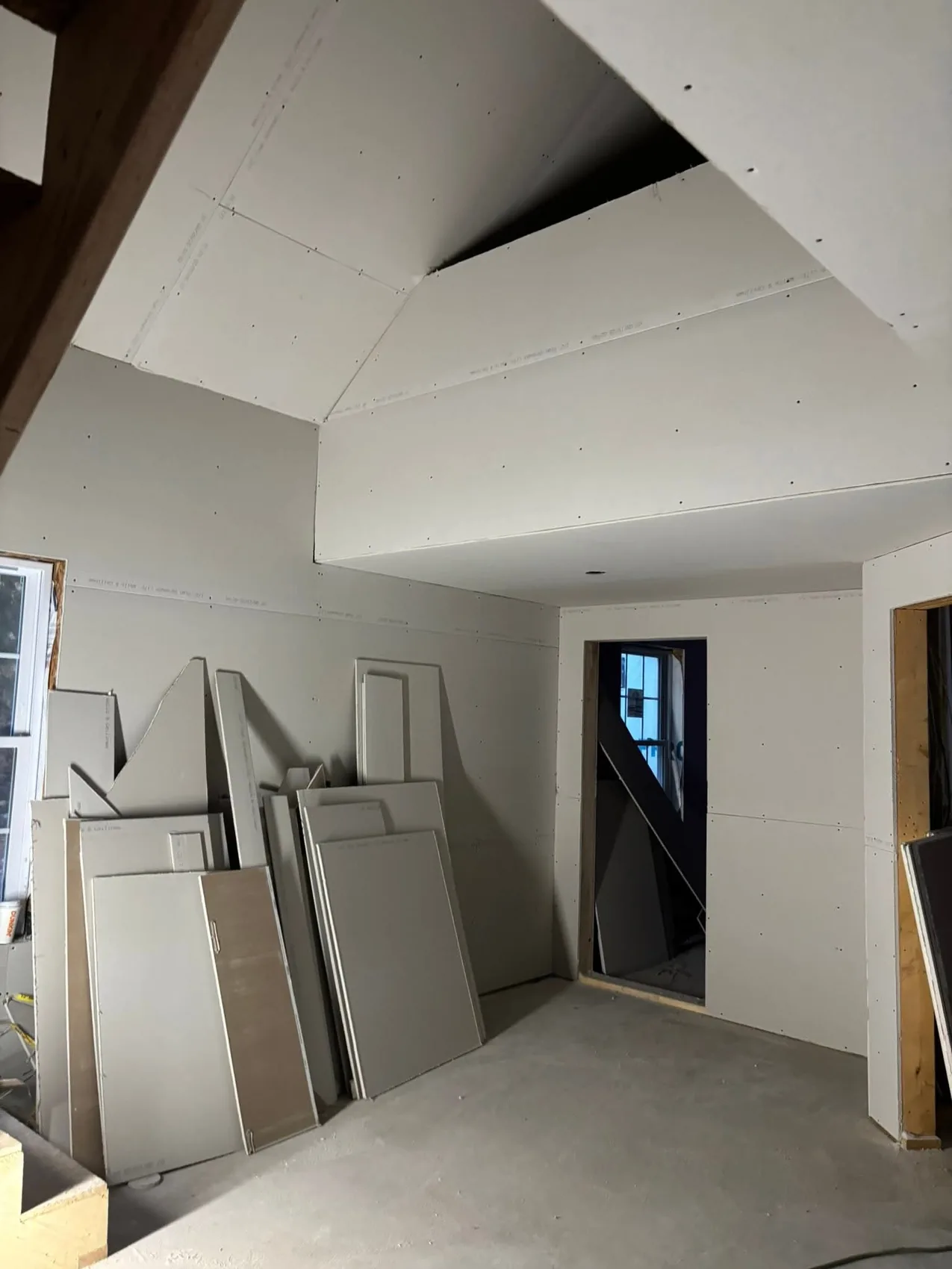 Drywall boards installed around a vaulted ceiling